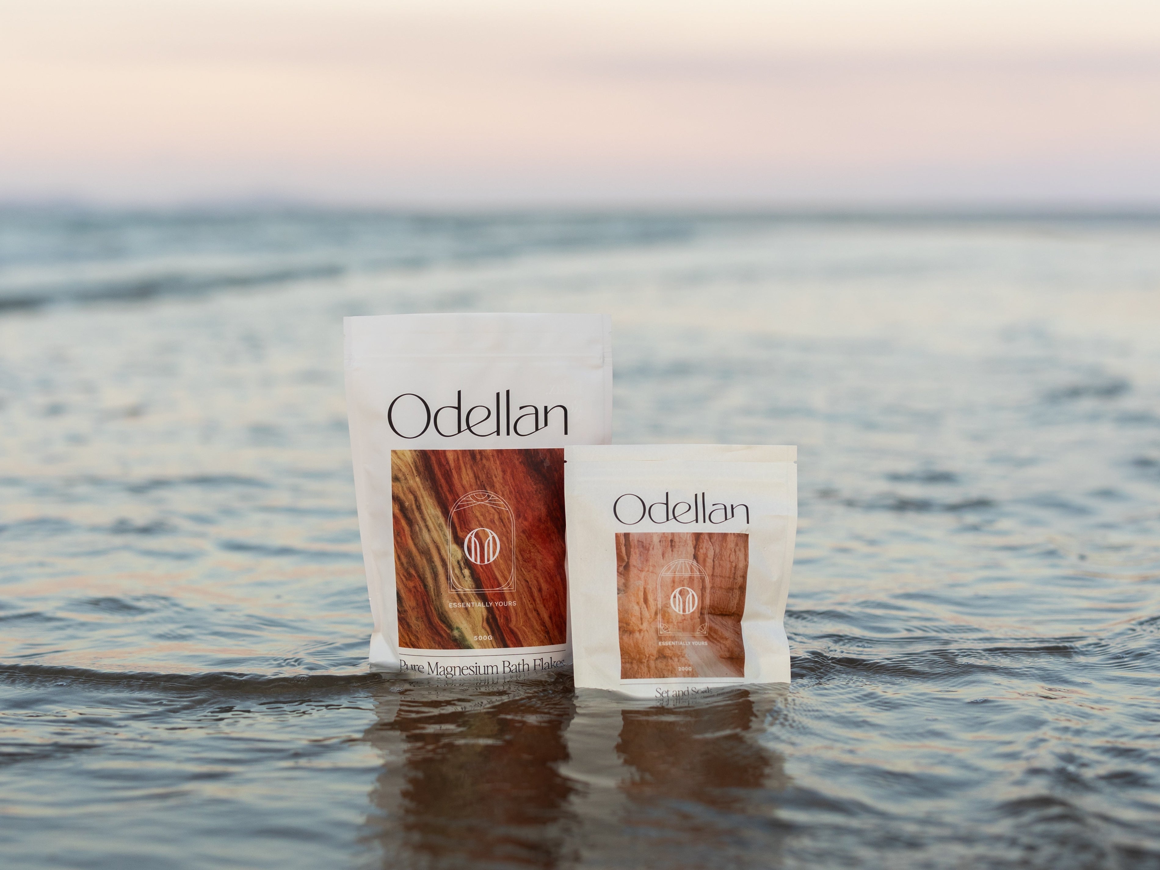 Odellan's Pure Magnesium Bath Flakes and Set & Soak sitting in the ocean