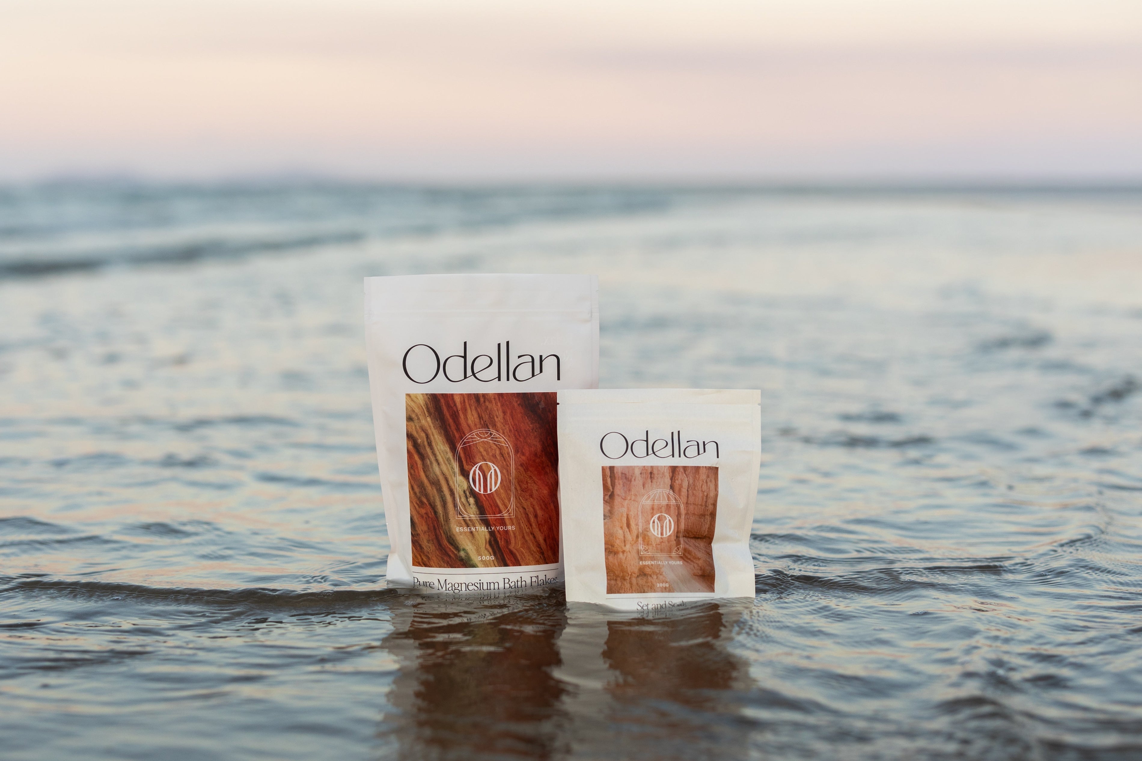 Odellan's Pure Magnesium Bath Flakes and Set & Soak sitting in the ocean